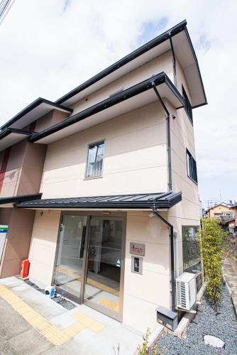 a house with a glass door on the side of it at アナザースカイ京都二条城 in Kinugasa