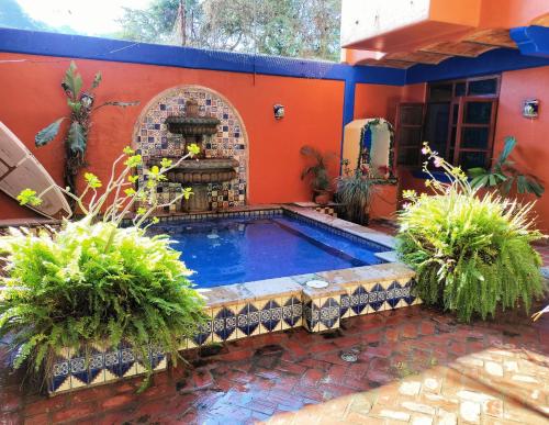 a swimming pool in a house with a fountain at Posada Las Flores in Los Ayala