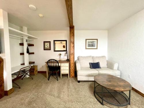 a living room with a white couch and a table at Sierra Mountain Lodge - Vacation Rentals - Yosemite in Ahwahnee
