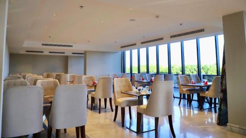 a dining room with tables and chairs and windows at Five Seasons Hotel in Tabuk