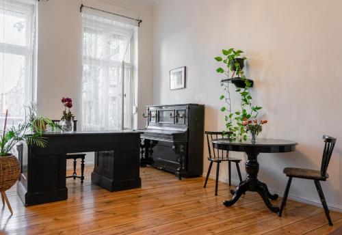 a living room with a piano and a table at Artistic Berlin Apartment in Berlin