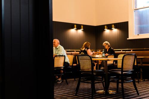 a group of people sitting at a table in a restaurant at The Victoria Hotel Rutherglen in Rutherglen