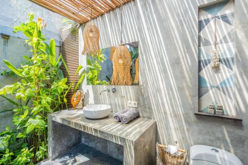 a bathroom with a sink and some plants at Ohana Boutique Villa by Hombali in Canggu