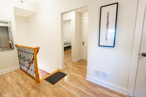 a hallway with a staircase and a mirror and a picture at Spacious 3 Bedroom Apartment in Heart of Niagara in Thorold