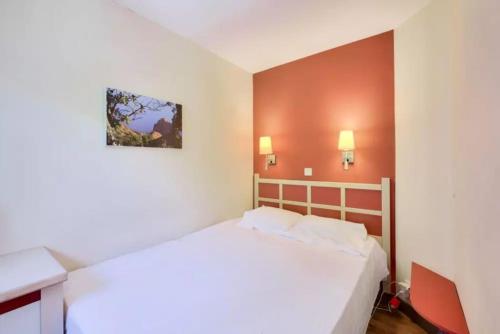 - une chambre avec un lit blanc et des murs orange dans l'établissement T2 clim-terrasse plein sud vue mer, à Cannes