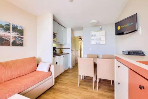 un salon avec un canapé et une table et une cuisine dans l'établissement T2 clim-terrasse plein sud vue mer, à Cannes