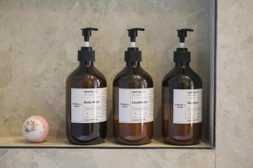 three bottles of wine sitting on a shelf at Pudding's Home Luxury Oceanfront Escape in Frankston