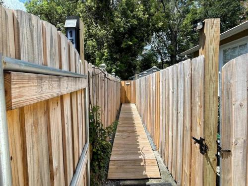a wooden fence with a wooden walkway next to a house at Stylish Bungalow Near Dining, Parks & Entertainment in Jacksonville