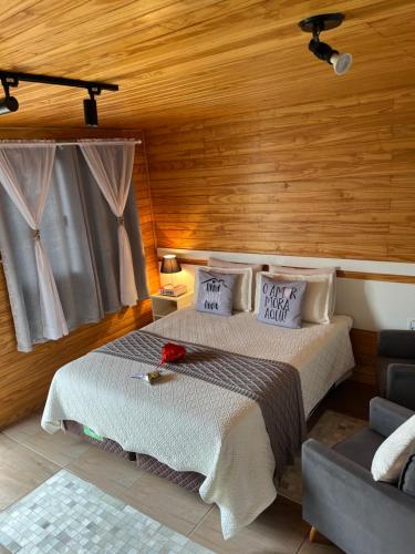 two beds in a room with wooden walls at Aconchego do Sereno Exclusive Chales in Urubici