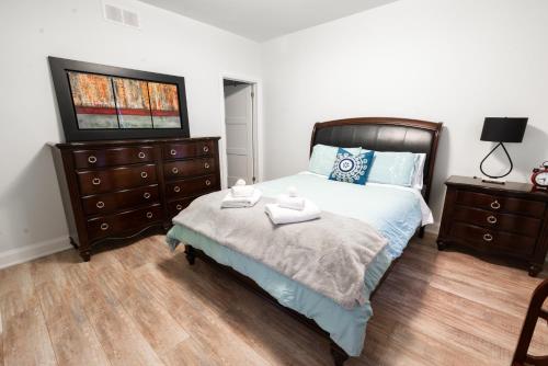 a bedroom with a bed and a dresser at Spacious 3 Bedroom Apartment in Heart of Niagara in Thorold