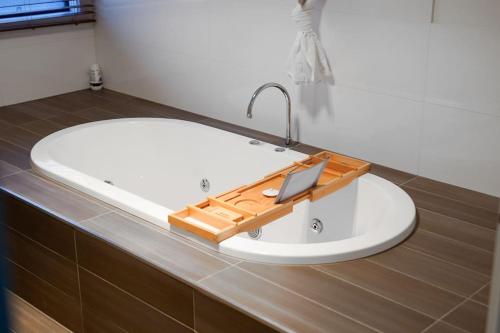 a bathroom with a bath tub with a sink at Bundoora Perfection - Luxury Family Oasis with pool in Bundoora