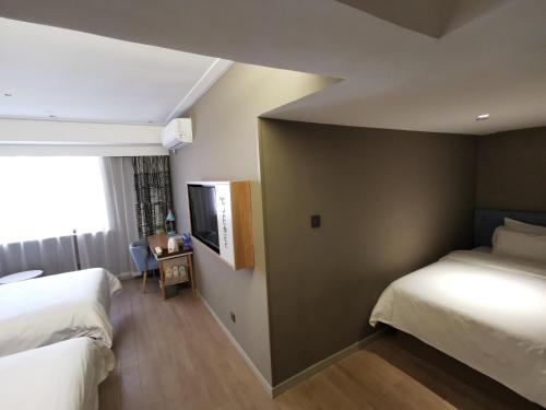 a hotel room with two beds and a window at Motel Xiamen Railway Station in Xiamen