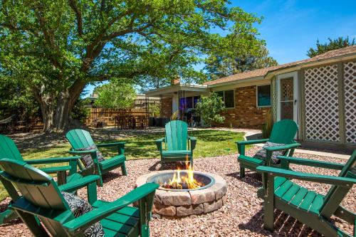 a group of green chairs around a fire pit at Oasis Retreat - Hot Tub - King Bd - Fire Pit - Games - Near Golf - 4 Bdrm - Sleeps up to 12 in Albuquerque
