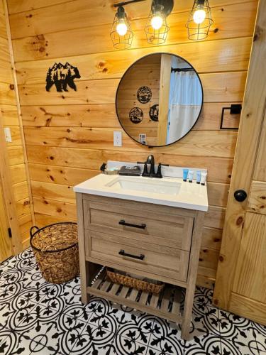 uma casa de banho com um lavatório e um espelho em Paradise at the Smokies Cabin em Sevierville