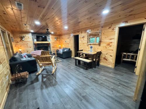 uma sala de estar num chalé de madeira com uma mesa e cadeiras em Paradise at the Smokies Cabin em Sevierville