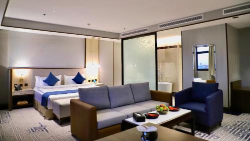 Five Seasons Hotel في تبوك: غرفه فندقيه بسرير واريكه