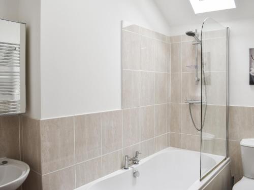 a bathroom with a shower and a tub and a toilet at The Towers in Witton le Wear