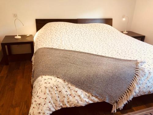 een bed met een deken en twee tafels bij Gite du Ried in Bischwiller