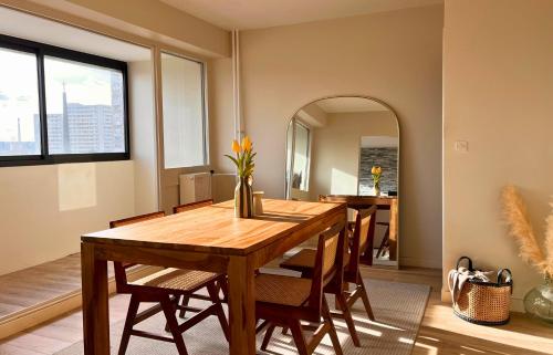 - une salle à manger avec une table en bois et un miroir dans l'établissement Lumina Coeur De Créteil Métro à 3 mn, à Créteil