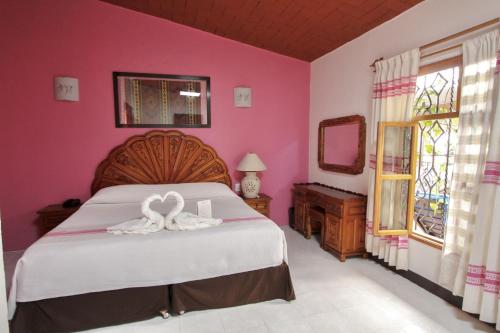 Un dormitorio con una cama con una decoración de corazón. en Hotel Anua Oaxaca, en Oaxaca City