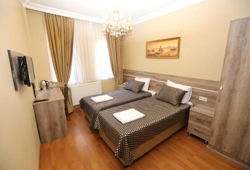 a living room with two beds and a chandelier at My Holiday Time Hotel in Istanbul