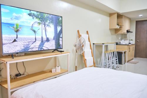 a bedroom with a large flat screen tv on a wall at QFandZ Baguio Homestay at BRENTHILL Condominium in Baguio
