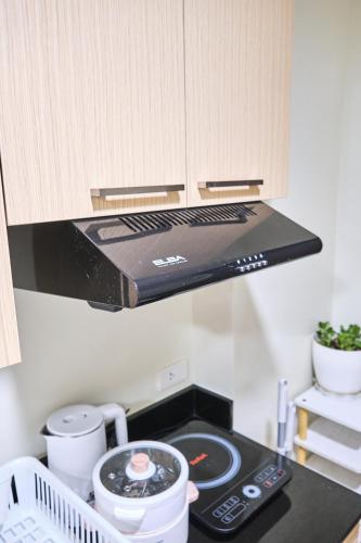 a kitchen with a stove top oven in a kitchen at QFandZ Baguio Homestay at BRENTHILL Condominium in Baguio