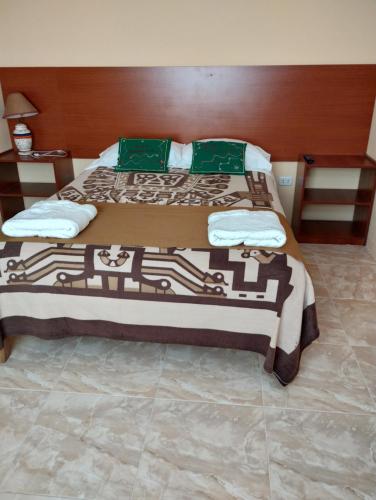 a bedroom with a large bed with green pillows at Hospedaje Casa Primavera in Cotahuasi