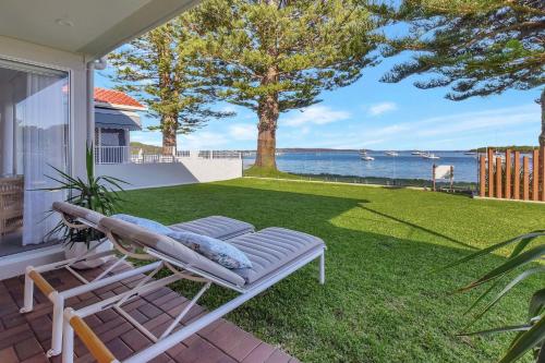 a porch with a hammock on the grass at Reflections at Sunset Beach in Soldiers Point