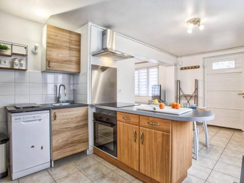 une cuisine avec des armoires en bois et un comptoir dans l'établissement Maison de ville avec 2 chambres et cuisine équipée au cœur de Cabourg, proche plage - 4 pers. - FR-1-788-1, à Cabourg