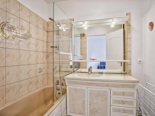 une salle de bain avec un lavabo, une baignoire et un miroir dans l'établissement Appartement cosy pour 4 à Cabourg avec balcon ensoleillé, à 400m de la plage - FR-1-788-6, à Cabourg
