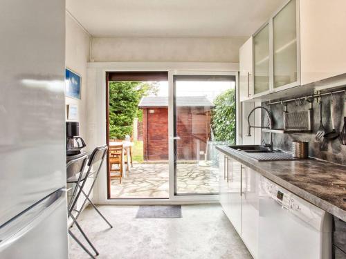- une cuisine avec vue sur la terrasse dans l'établissement Maison Duplex 6 Couchages, Confort, Jardin, Parking Privé, à 50m de la Plage - FR-1-788-9, à Merville-Franceville-Plage