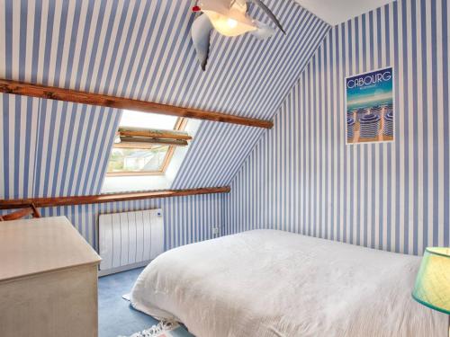- une chambre avec un lit et un mur rayé bleu et blanc dans l'établissement Maison Duplex 6 Couchages, Confort, Jardin, Parking Privé, à 50m de la Plage - FR-1-788-9, à Merville-Franceville-Plage
