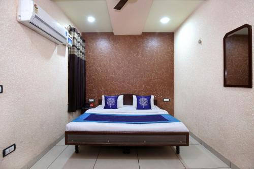 a bedroom with a bed with blue pillows at OYO 9808 Hotel Prem Sagar in Ludhiana