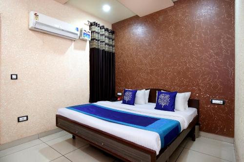 a bedroom with a bed with blue and white pillows at OYO 9808 Hotel Prem Sagar in Ludhiana