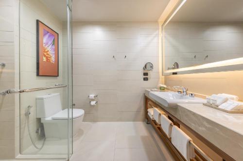 a bathroom with a toilet and a sink and a shower at Eastin Grand Hotel Sathorn in Bangkok
