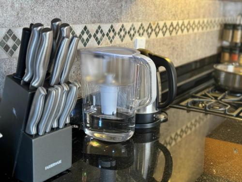 a blender sitting on top of a counter with knives at # Marbella Lane - Vibrant 5BR Home in Daly City in Daly City