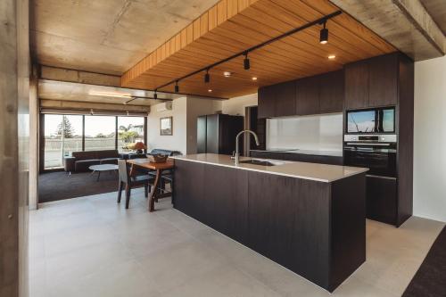 a kitchen with a sink and a table in a room at The Coomber - Apartments & Studios in New Plymouth