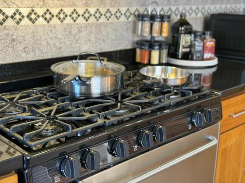 two pots and pans on a stove in a kitchen at # Marbella Lane - Vibrant 5BR Home in Daly City in Daly City