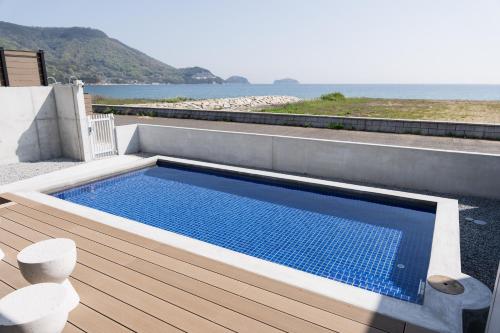 a swimming pool on a deck with a view of the ocean at SETO CLAS TSUDA THE BEACH RESORT C in Yoshimi