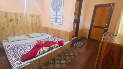 a woman laying on a bed in a room at त्रिnity homestay in Kasol