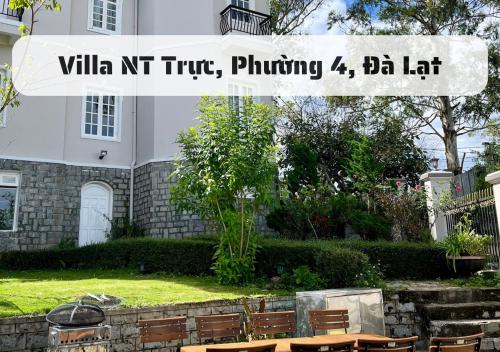 znak przed budynkiem ze stołami i krzesłami w obiekcie Hệ Thống Villa Đà Lạt w mieście Da Lat
