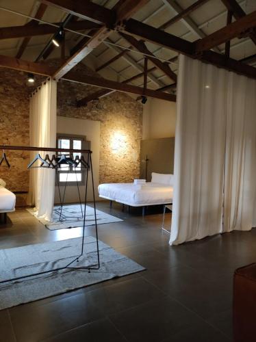 a room with two beds and a white curtain at Ático loft en molino antiguo in Paterna