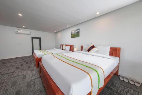 two beds in a room with white walls at Central Sapa Serenity Homestay in Sa Pa