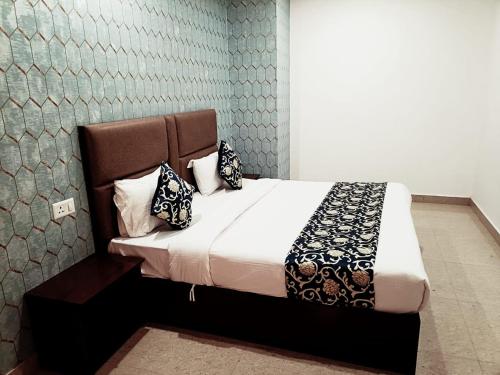 Un dormitorio con una cama con almohadas. en Hotel Ambience Dilli 37 At - Near IGI Airport en Nueva Delhi