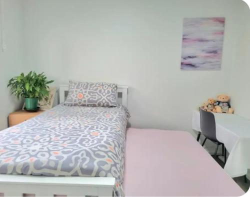 ein weißes Schlafzimmer mit einem Bett und einem Tisch in der Unterkunft Cozy Room Near Christchurch Airport in Christchurch