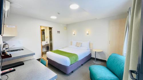 Habitación de hotel con cama y sofá en Bella Vista Motel Whangarei, en Whangarei
