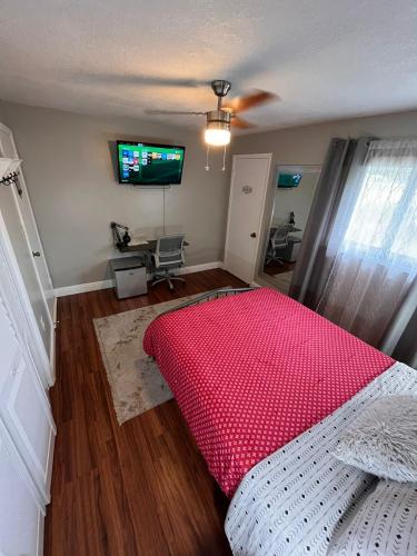 a bedroom with a bed and a flat screen tv at Spanish Style House - Free Parking in Miami