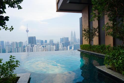 a swimming pool with a city skyline in the background at Harmony Luxury Suites At Lucentia Bukit Bintang City Center in Kuala Lumpur