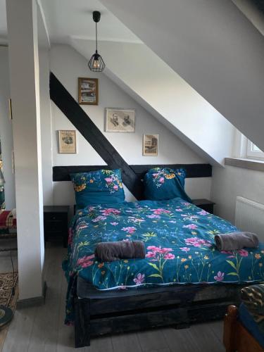 a bedroom with a bed with a blue comforter at Palac Osowo gostynskie in Gostyń